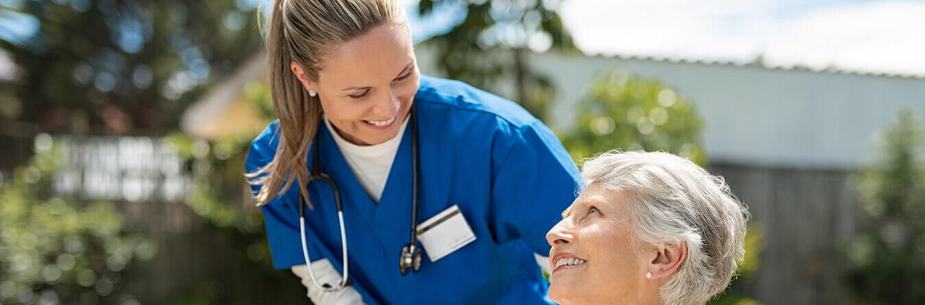 Nurse taking care of old woman in wheelchair