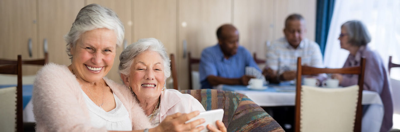 smiling senior taking selfie with friend